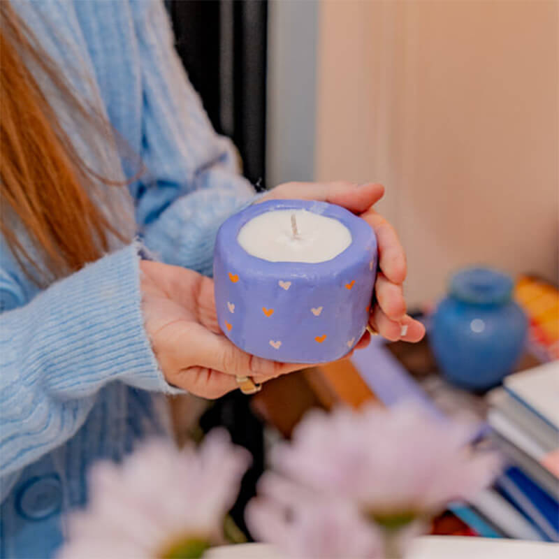 A woman handling her finish candle making creation